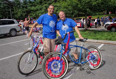 Two people standing with bicycles decorated in red, white and blue.